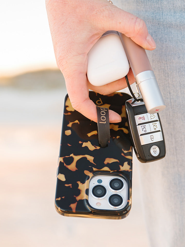 A woman holding a Tortoise Loopy Case. || feature-media