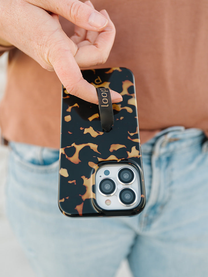 A woman holding a Tortoise Loopy Case. || feature-media