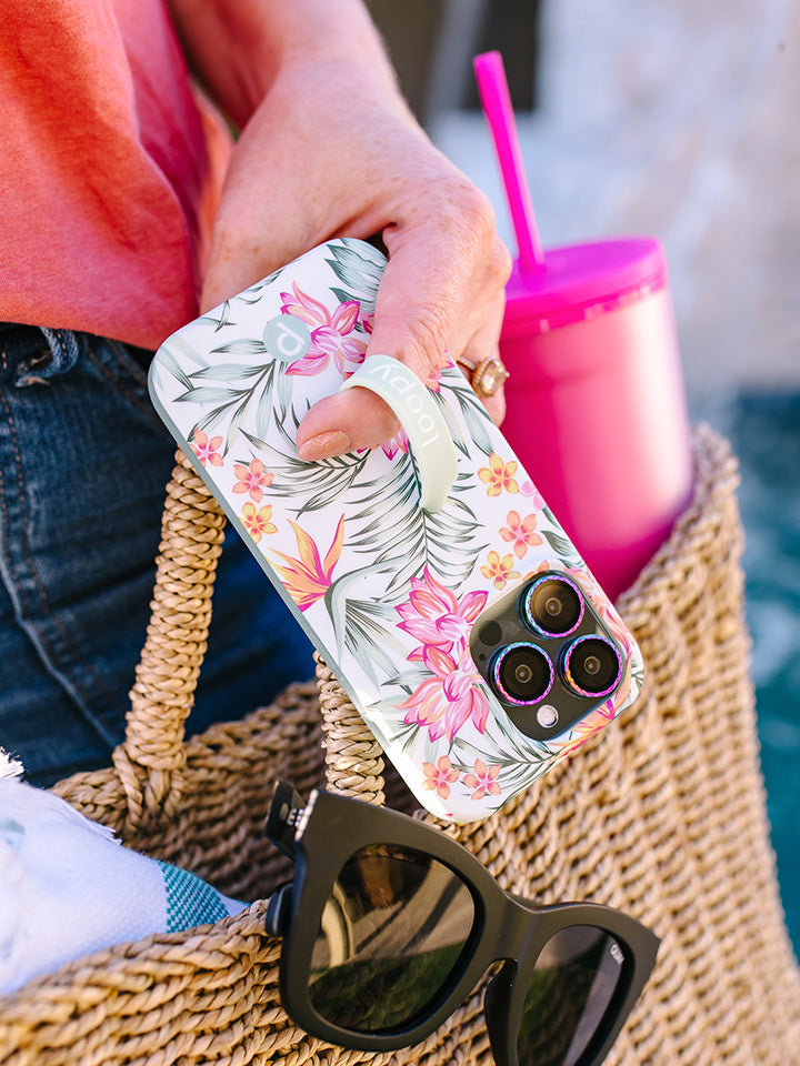 A woman holding a Tropical Blooms Loopy Case.|| feature-media