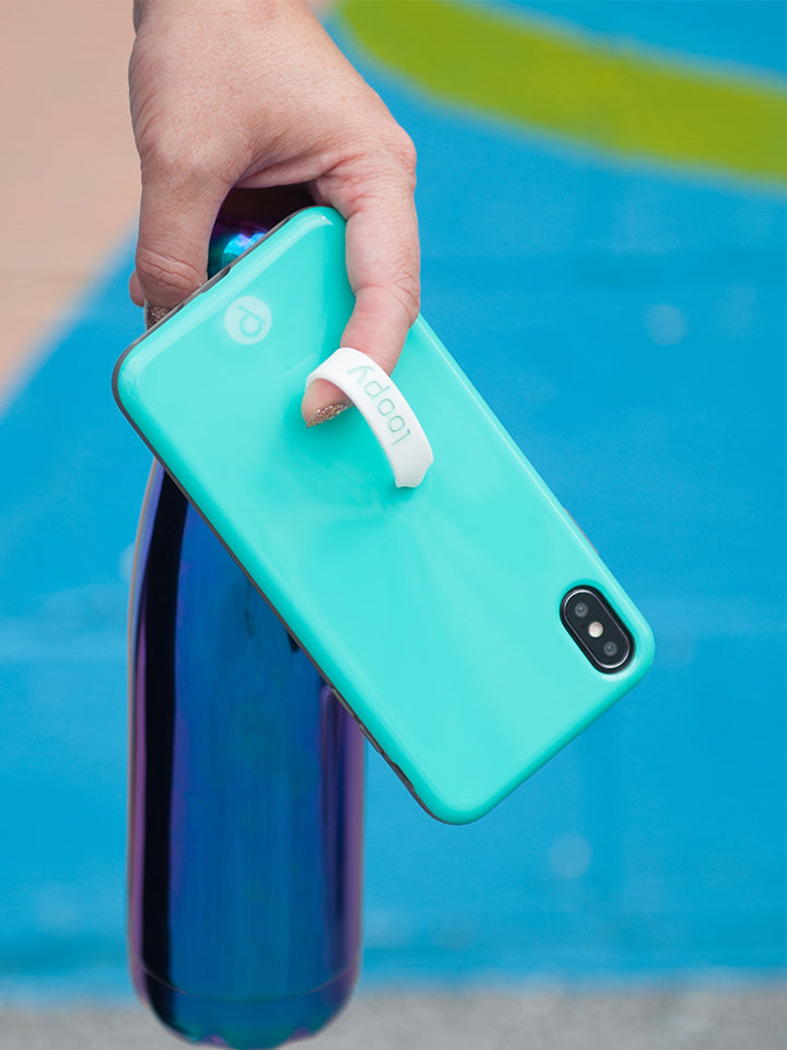 A woman holding a Turquoise Loopy Case. || feature-media