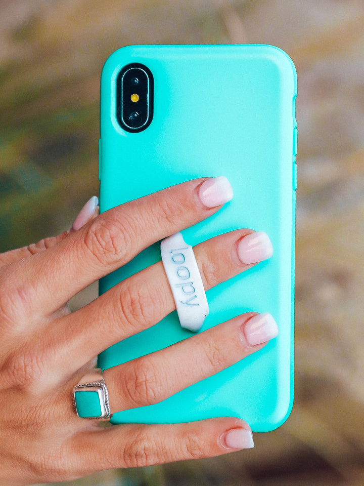 A woman holding a Turquoise Loopy Case. || feature-media