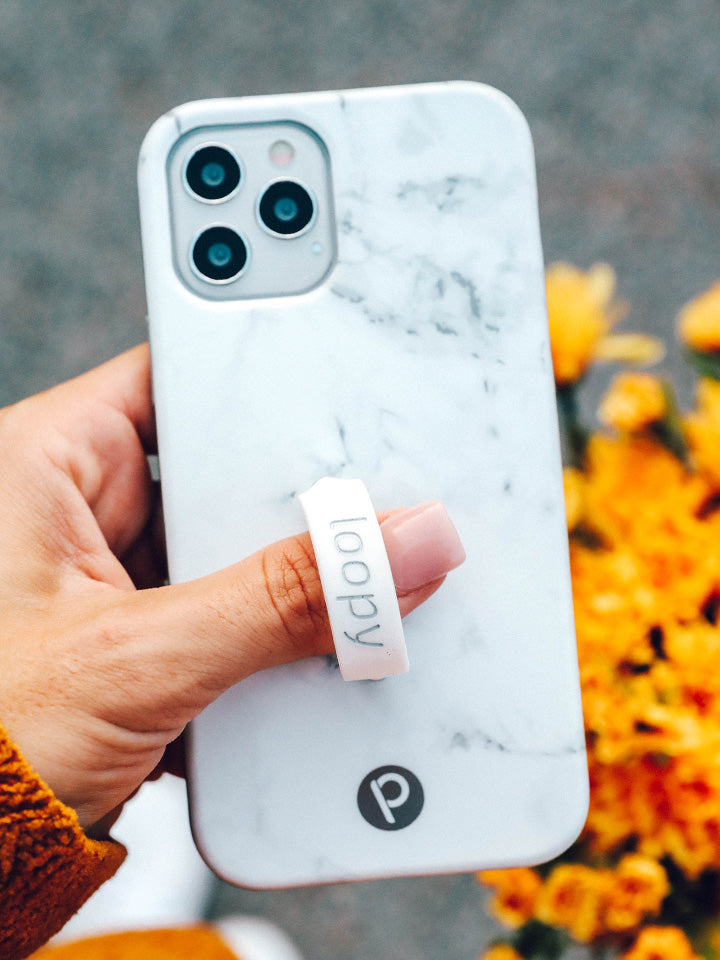 A woman holding a White Marble Loopy Case.|| feature-media