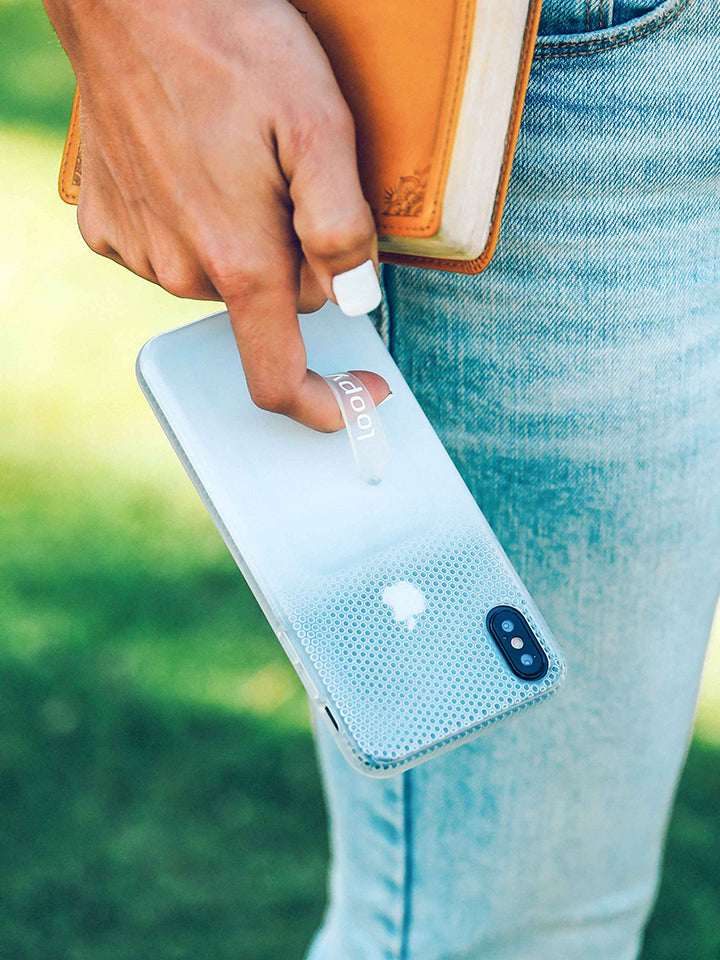 A woman holding a White Ombre Loopy Case. || feature-media