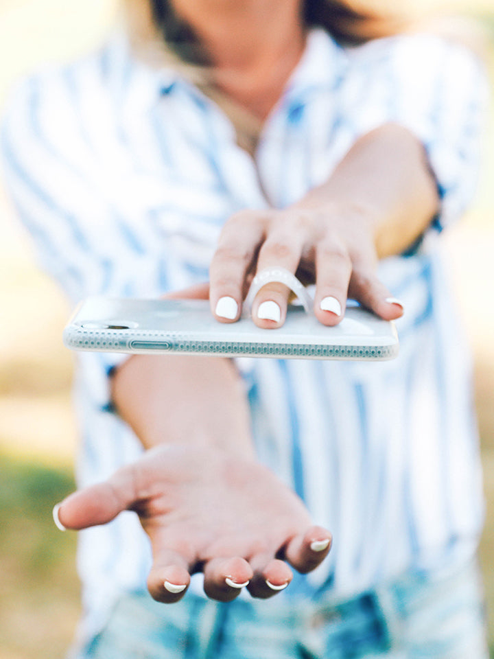 A woman holding a White Ombre Loopy Case. || feature-media