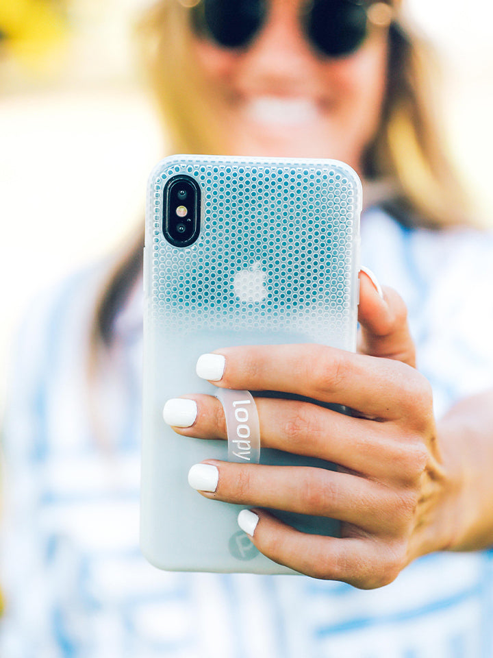 A woman holding a White Ombre Loopy Case. || feature-media