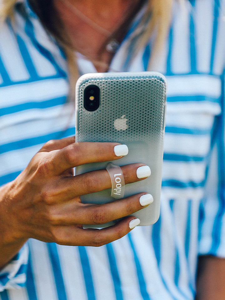 A woman holding a White Ombre Loopy Case. || feature-media