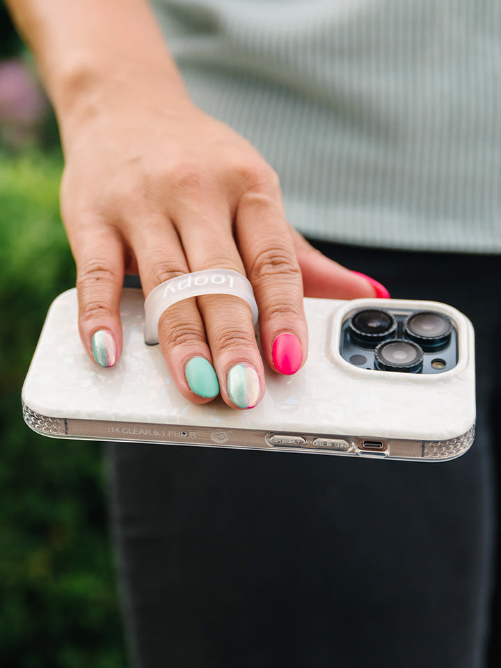 A woman holding a White Opal Shell Loopy Case. || feature-media