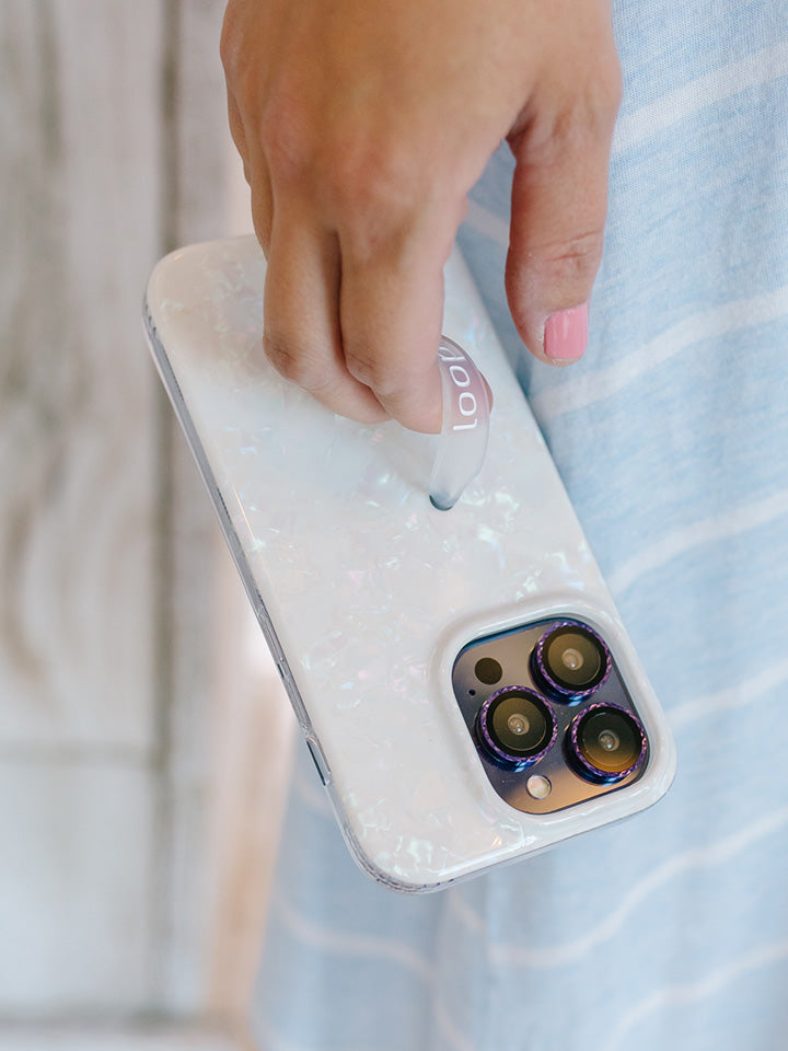 A woman holding a White Opal Shell Loopy Case.|| feature-media