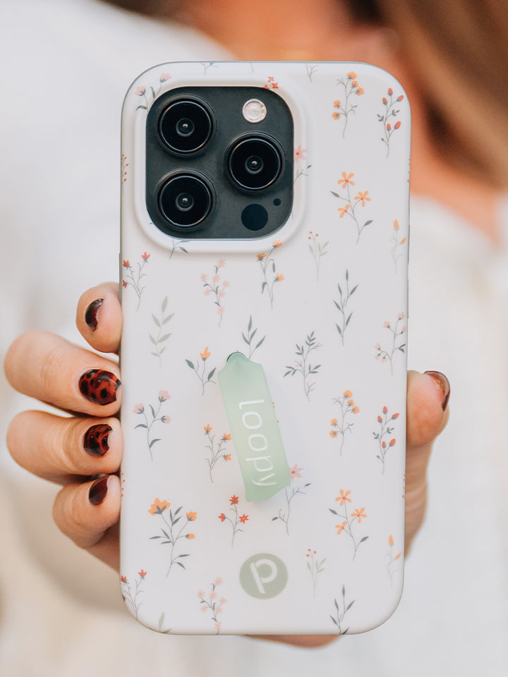 A woman holding a Whispering Wildflowers Loopy Case. || feature-media