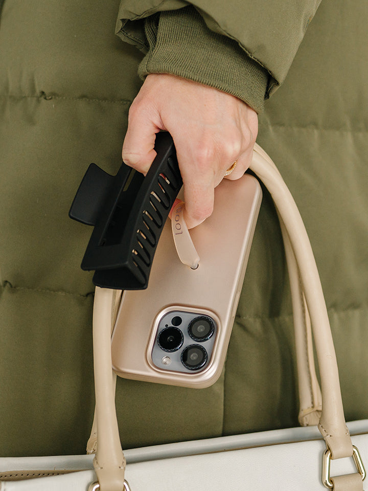 A woman holding a Desert Metallic Loopy Case. || feature-media