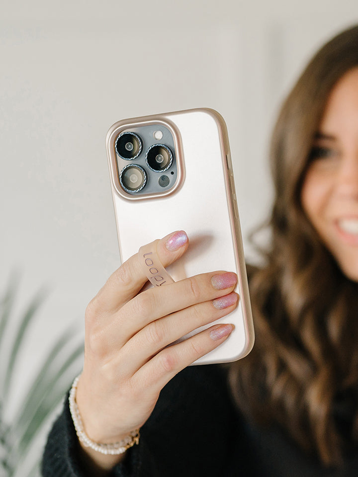 A woman holding a Desert Metallic Loopy Case. || feature-media