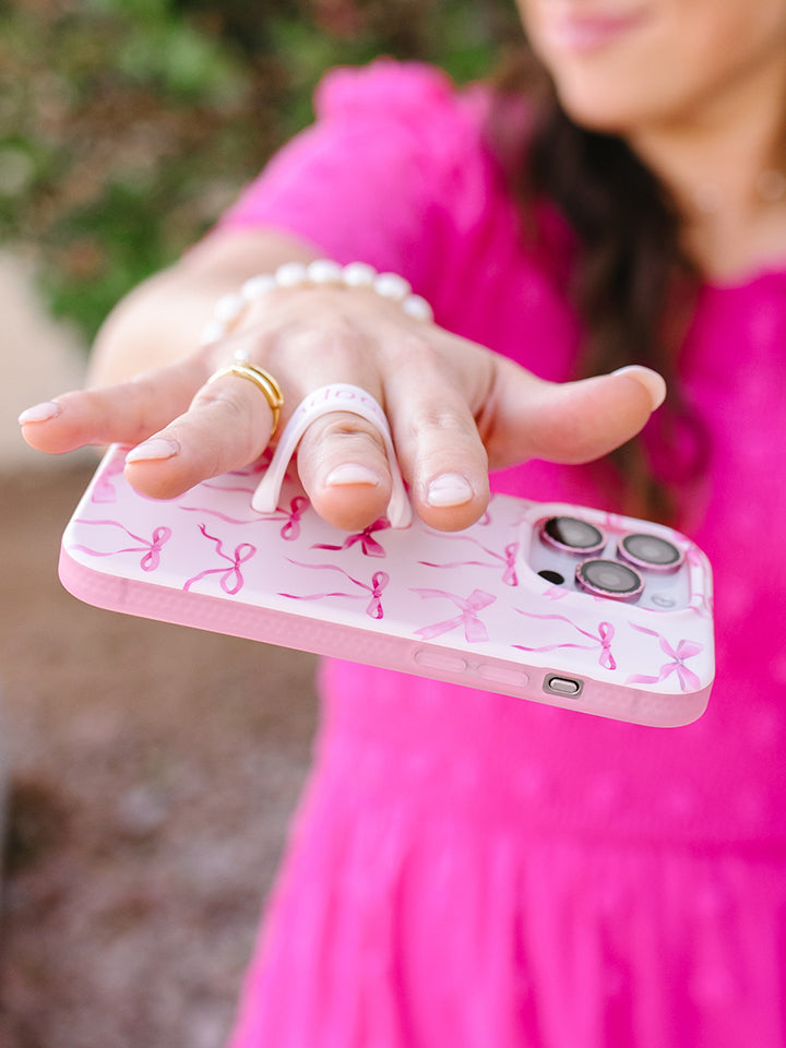 A woman holding a Pink Bows Loopy Case. || feature-media