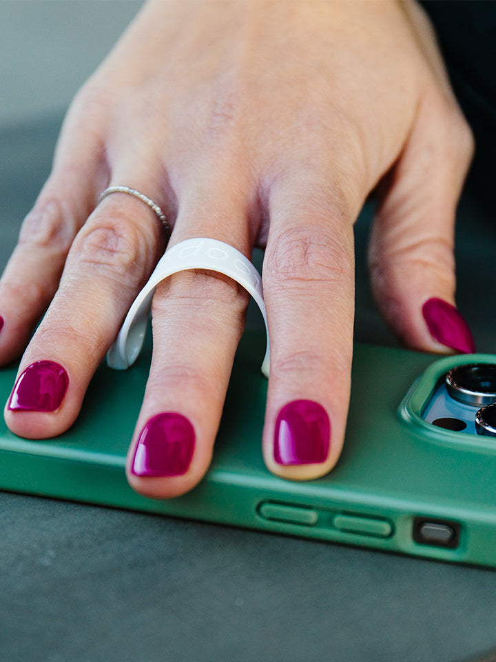 A woman holding a Loopy Case that has a Thin Loop on it. || feature-media