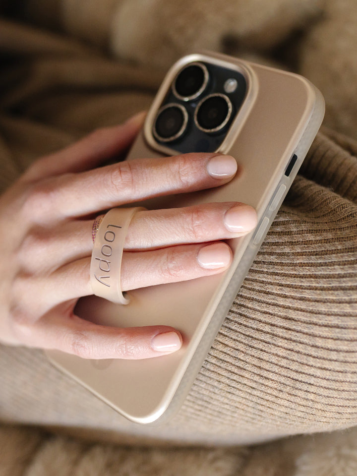 A woman holding a Desert Metallic Loopy Case. || feature-media