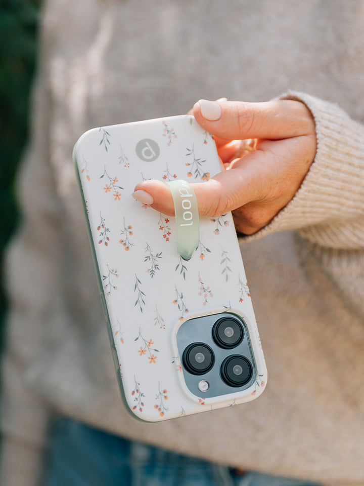 A woman holding a Whispering Wildflowers Loopy Case. || feature-media