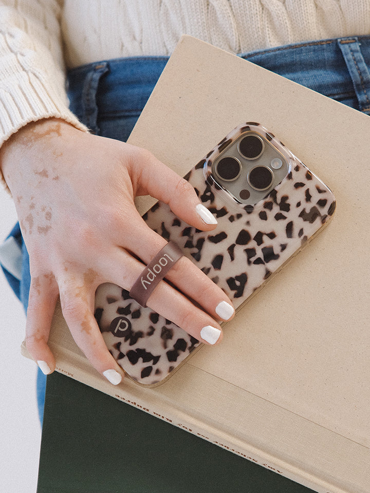 A woman holding a Blonde Tortoise Loopy Case. || feature-media