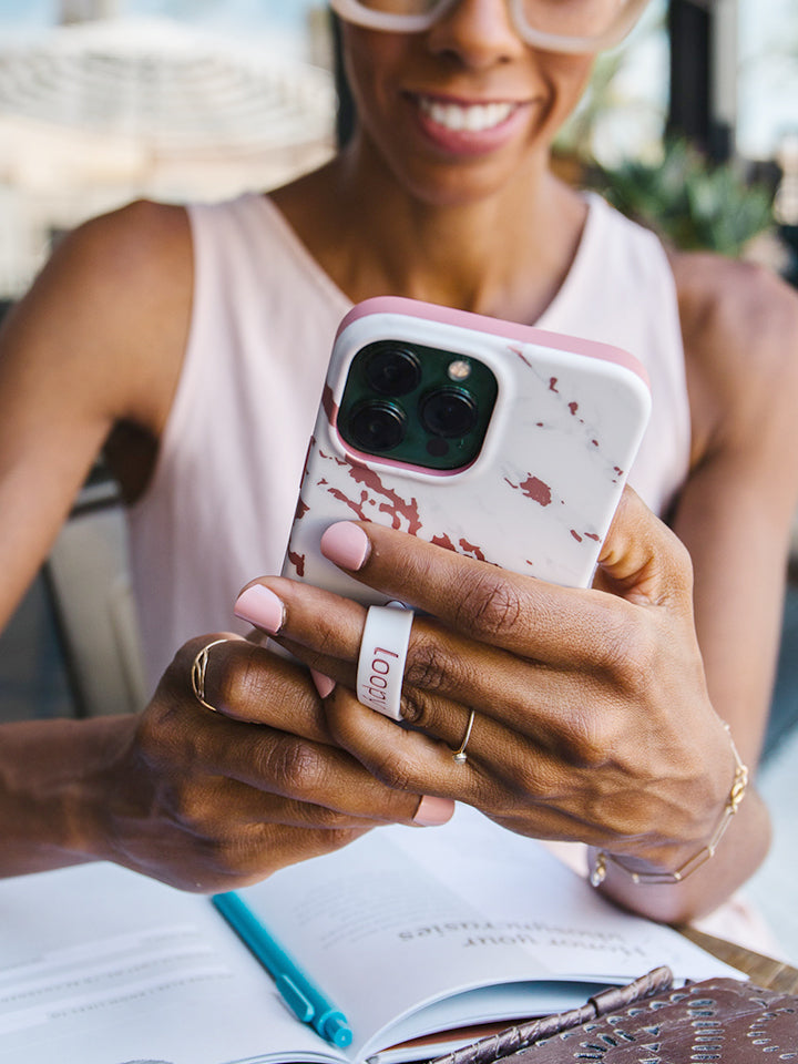 A woman holding a Rose Marble Metallic Loopy Case.|| feature-media