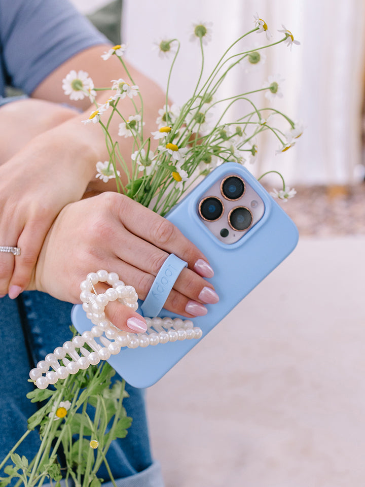 A woman holding a Sierra Blue Loopy Case. || feature-media