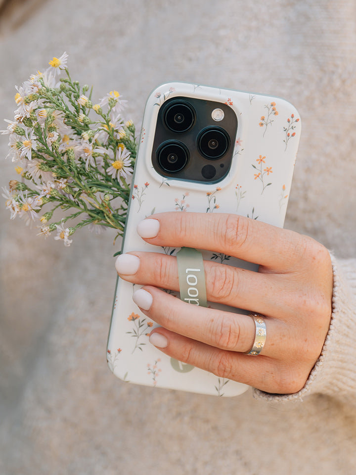  A woman holding a Whispering Wildflowers Loopy Case.|| feature-media