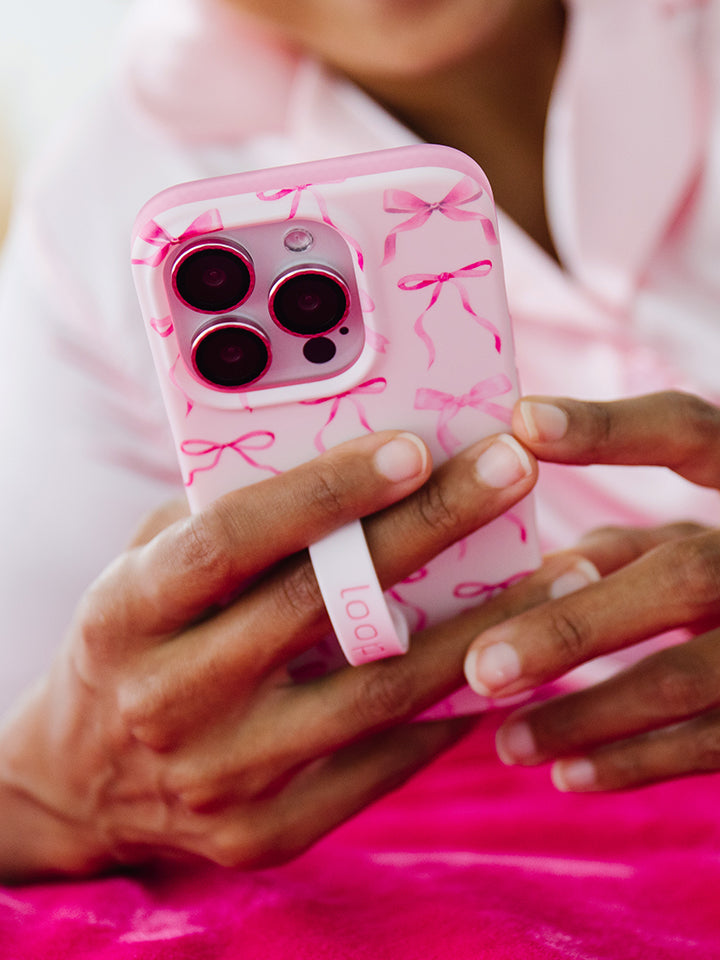 A woman holding a Pink Bows Loopy Case.|| feature-media