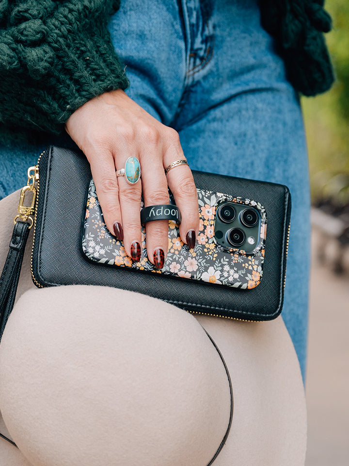 A woman holding a Vintage Blooms Loopy Case. || feature-media