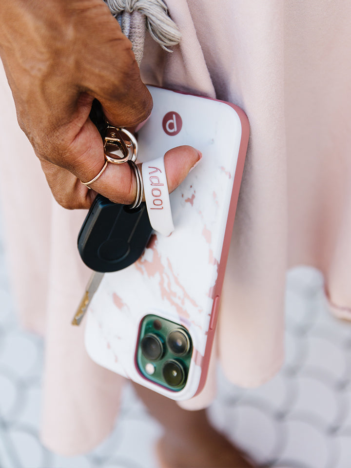 A woman holding a Rose Marble Metallic Loopy Case.|| feature-media