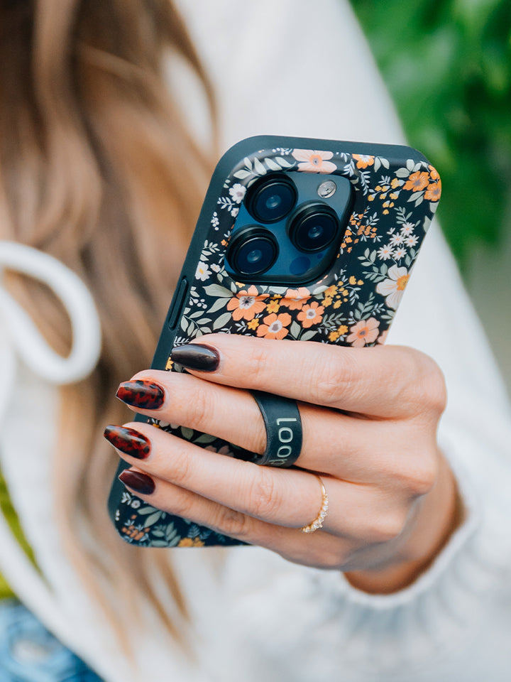 A woman holding a Vintage Blooms Loopy Case. || feature-media