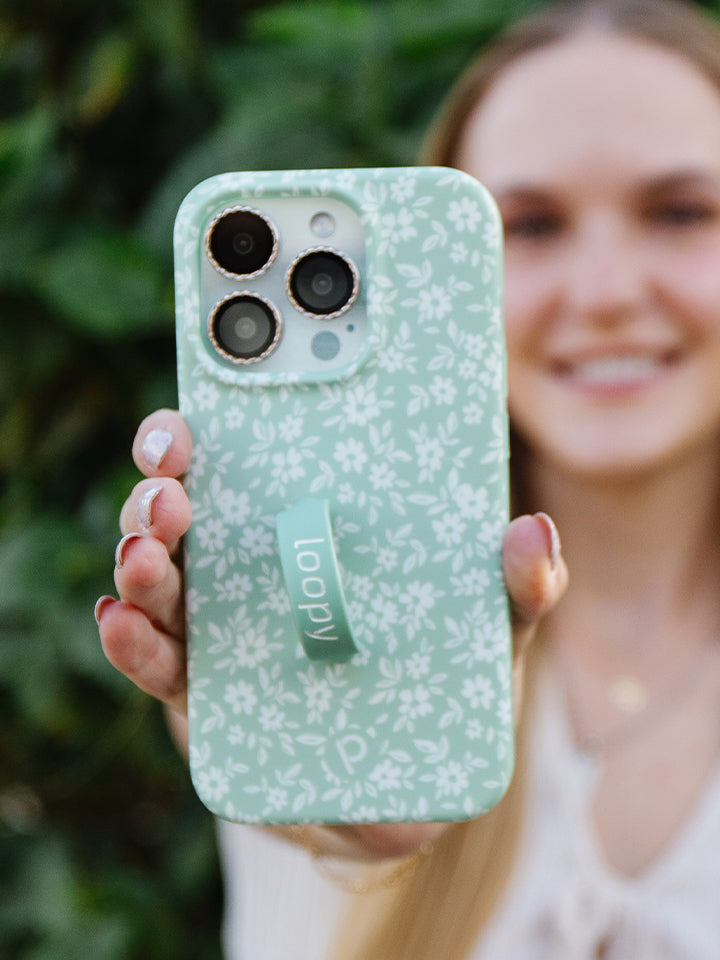  A woman holding a Sage Floral Loopy Case.|| feature-media