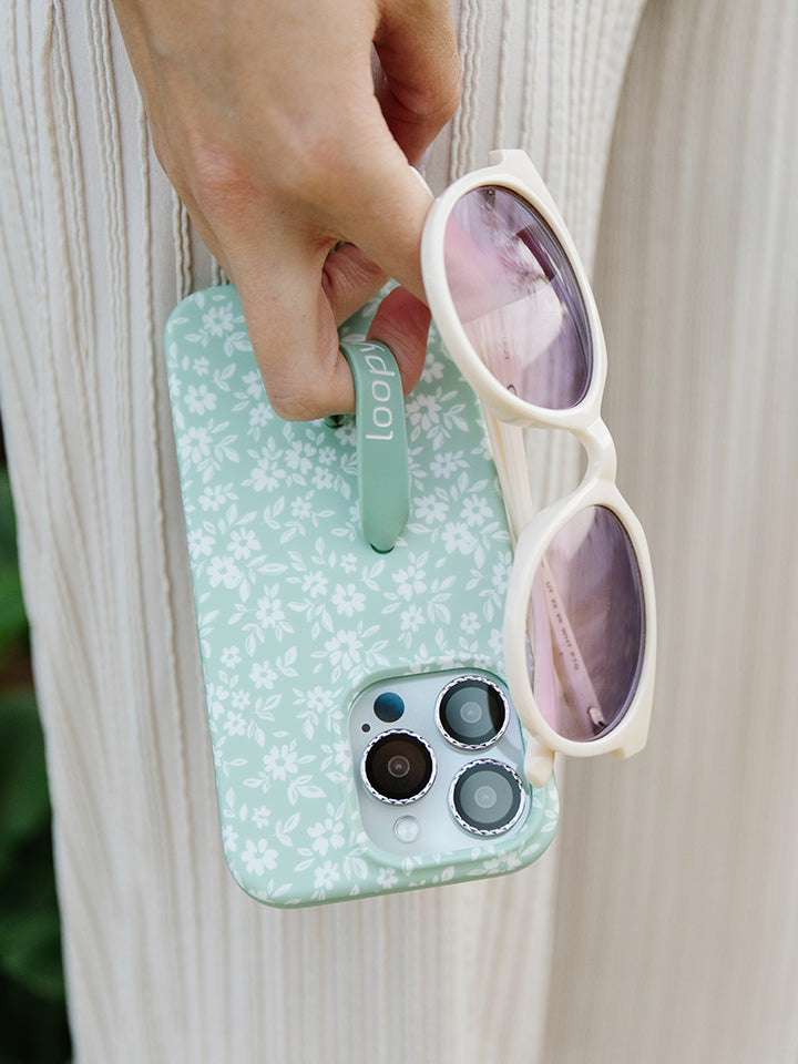 A woman holding a Sage Floral Loopy Case. || feature-media