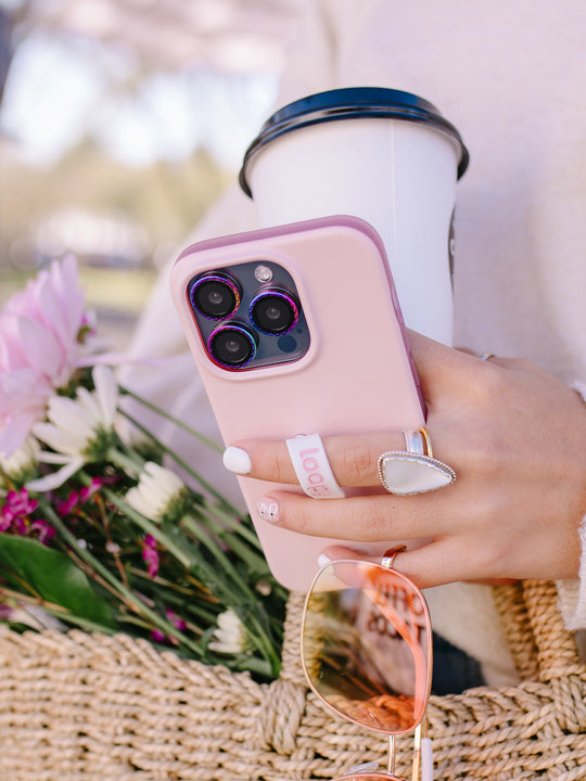 A woman holding a Blush Loopy Case.