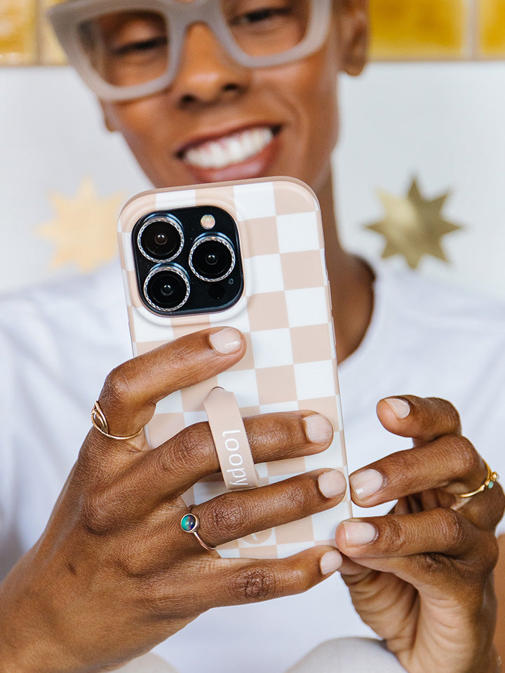 A woman holding a Sand Dollar Checkered Loopy Case. || feature-media