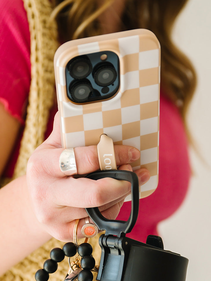 A woman holding a Sand Dollar Checkered Loopy Case. || feature-media