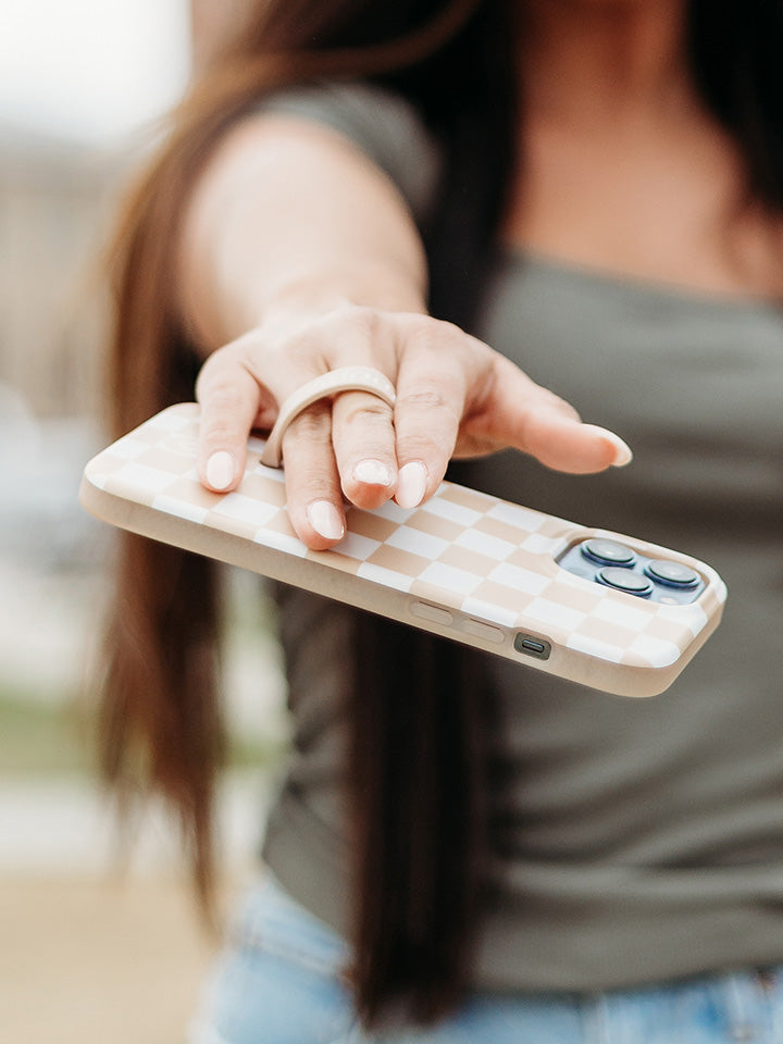 A woman holding a Sand Dollar Checkered Loopy Case. || feature-media