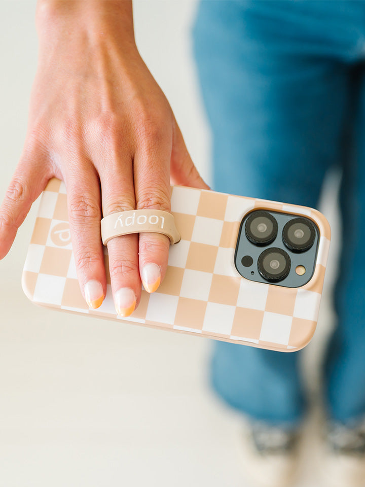 A woman holding a Sand Dollar Checkered Loopy Case. || feature-media