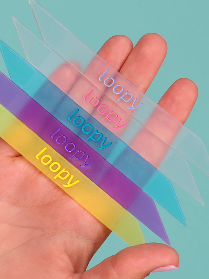 A woman holding five of the Loopy Cases Translucent Loops.